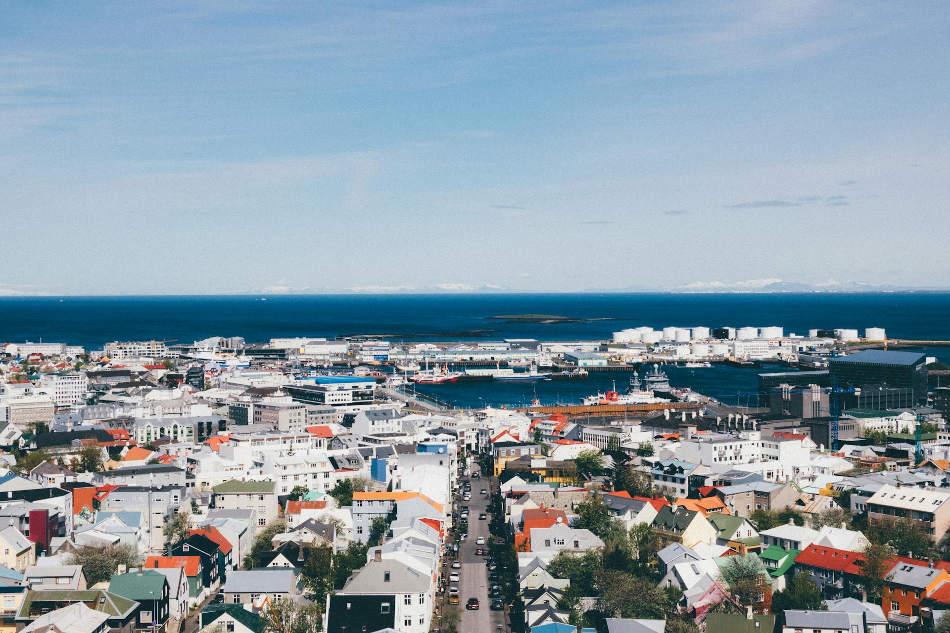 Scenic view of Reykjavik cityscape with vibrant buildings and ocean backdrop.
