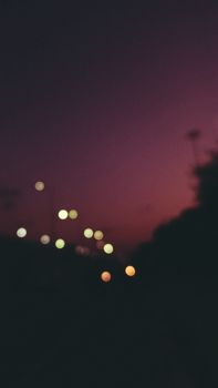 Atmospheric shot capturing faint streetlights against a blurred twilight sky in Delhi, India.