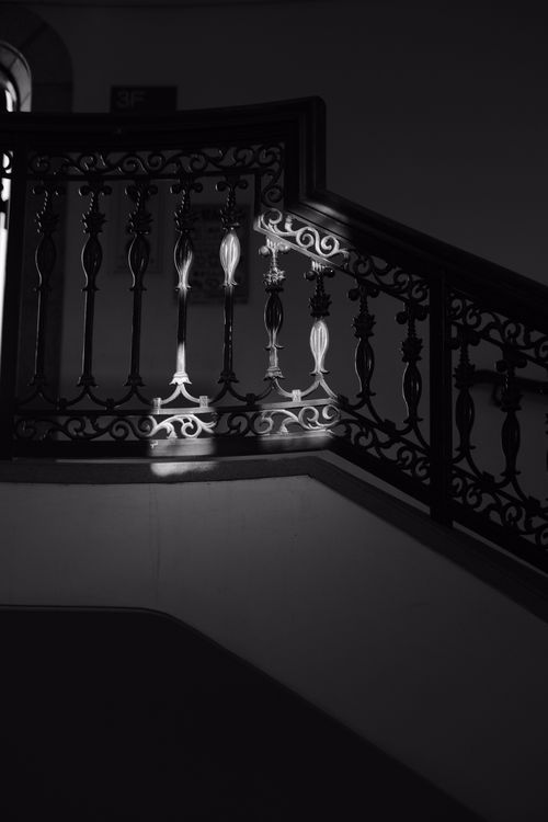 Free Intricate metal railings cast artistic shadows on a staircase in monochrome. Stock Photo