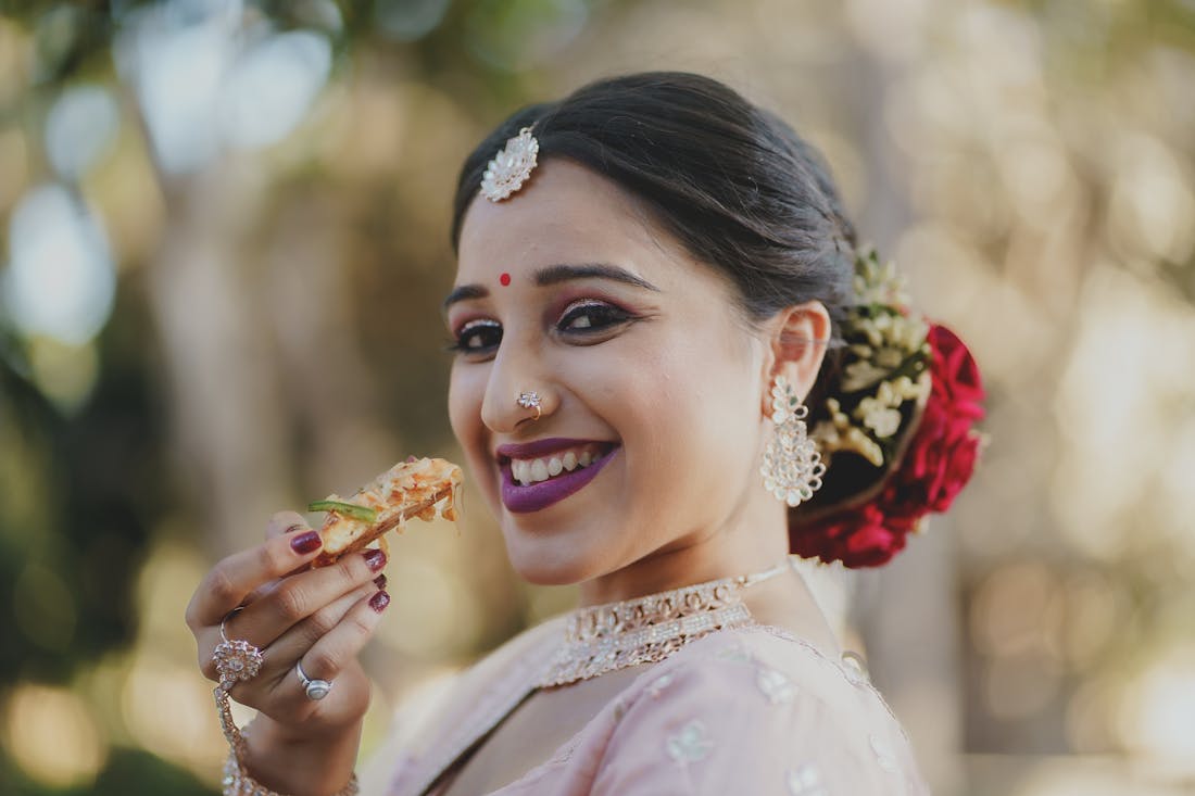 Bride in a rose gold gown smiling outdoors during a break