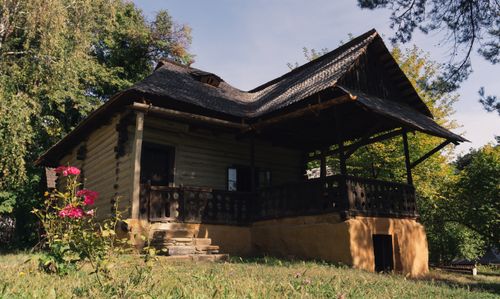 Free Beautiful rustic wooden cabin surrounded by lush trees and vibrant flowers, a perfect escape. Stock Photo