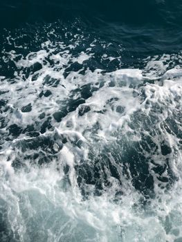Close-up of ocean waves with white foam, showcasing the dynamic movement and texture of water.