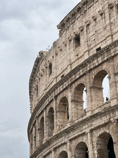Free Vertical shot of the ancient Colosseum in Rome framed by an overcast sky, iconic Roman landmark. Stock Photo