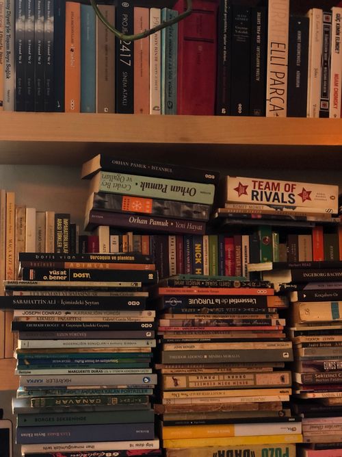 Free A stacked and colorful collection of diverse books on a wooden shelf, perfect for literature lovers. Stock Photo