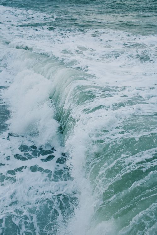 Free Captivating vertical shot of powerful ocean waves crashing with frothy foam. Stock Photo