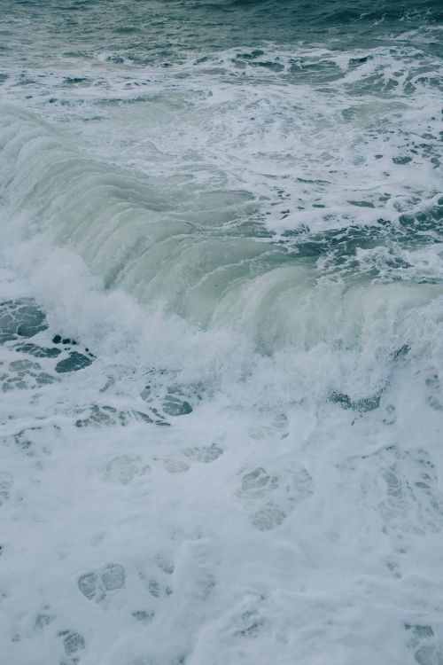 Free High angle view of ocean waves cresting and crashing with white foam in a powerful display of nature. Stock Photo