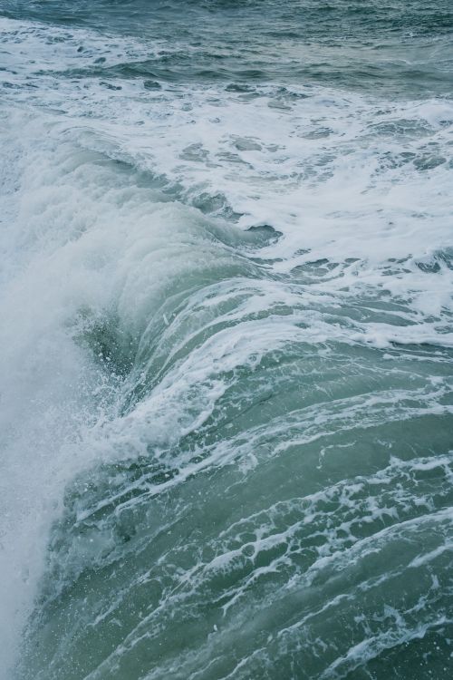 Free Photograph capturing the power and beauty of a cascading ocean wave with frothy foam. Stock Photo
