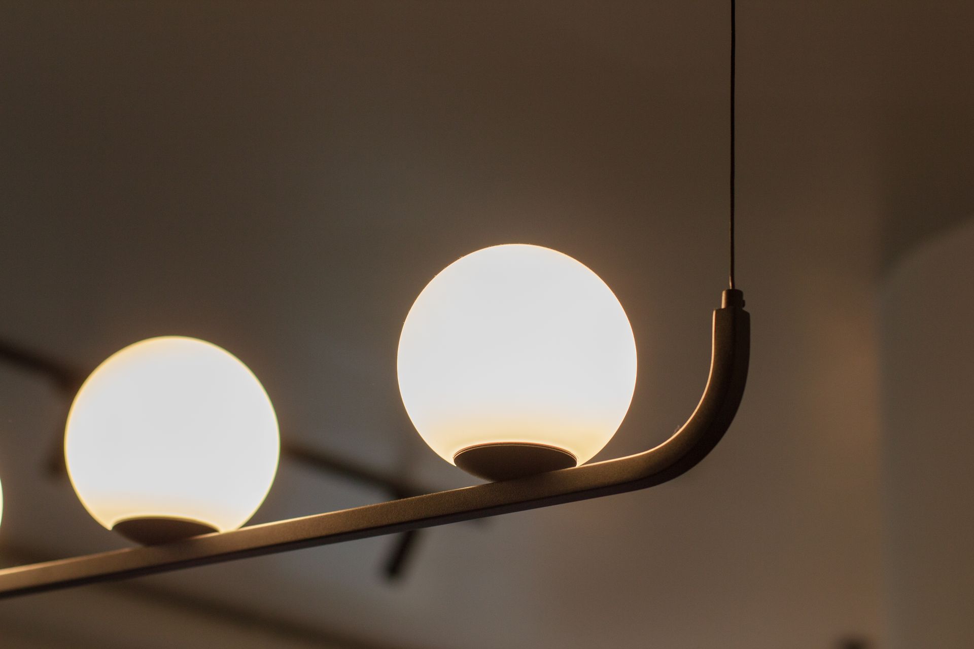 Close-up of contemporary spherical pendant lamp with warm illumination indoors.