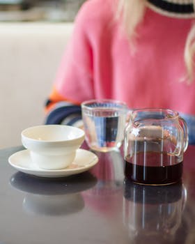 Elegant table setting with coffee and cup, complemented by casual clothing. Ideal for breakfast themes.