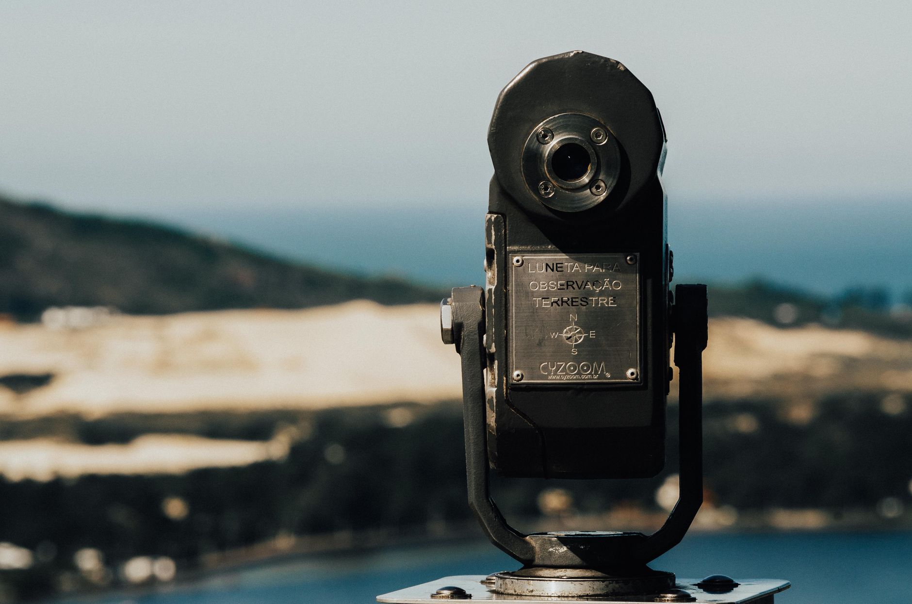 Coin operated telescope on a viewing platform with scenic view of Lagoa da Conceição, Brazil.