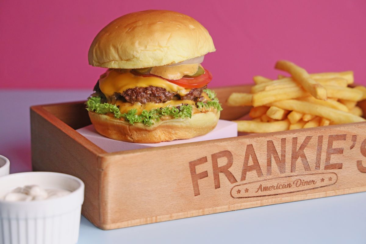 Classic American diner burger served with crispy french fries on a tray