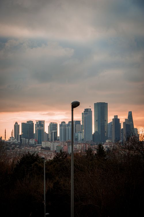 Free Panoramic view of a city's skyscrapers under a dramatic sunset sky. Stock Photo