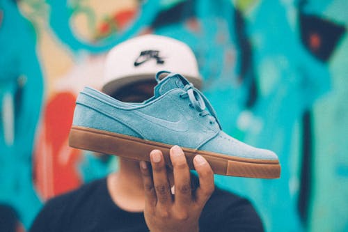 Free Person Holding Nike Sb Suede Low-top Sneaker Stock Photo
