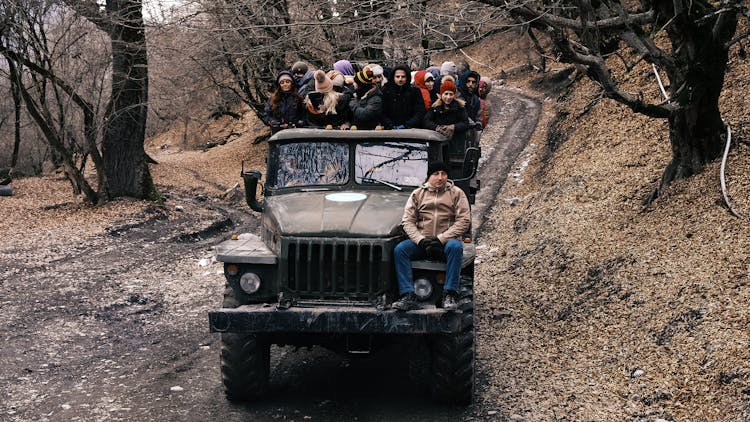 Truck With Group Of People In Forest