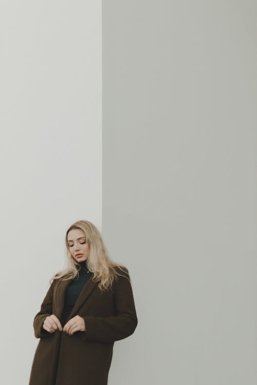 Woman Standing by the White Wall 