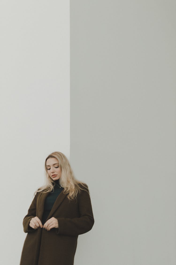 Woman Standing By The White Wall 