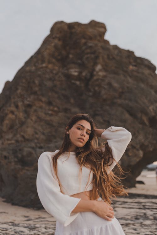 Photo of a Woman Standing in front of a Rock 