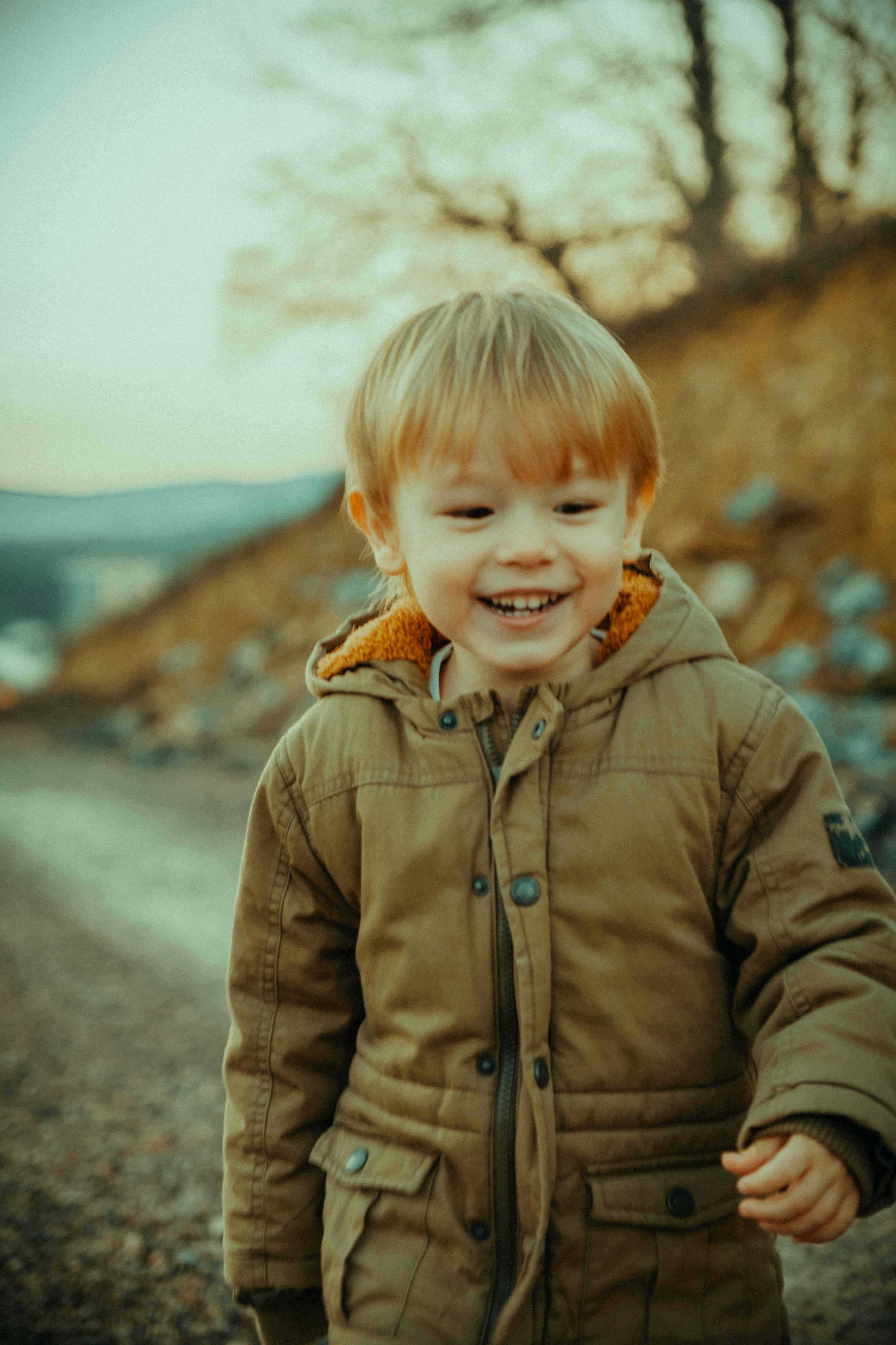 smiling boy wearing a brown jacket