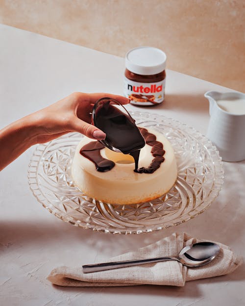 Woman Adding Chocolate Cream to Cake