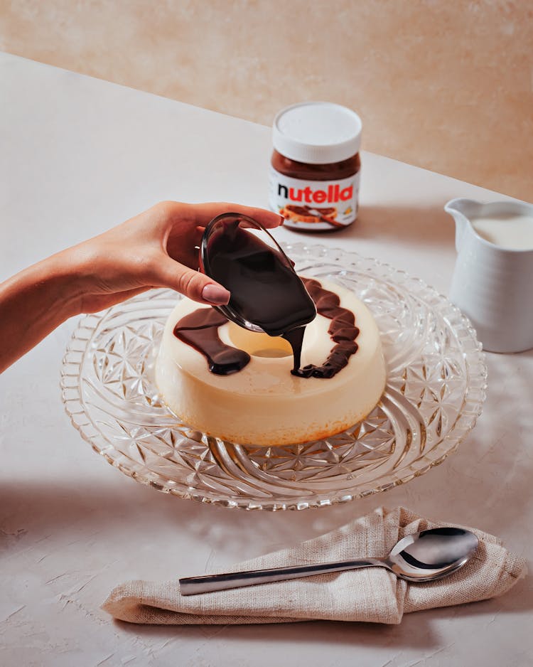 Woman Adding Chocolate Cream To Cake