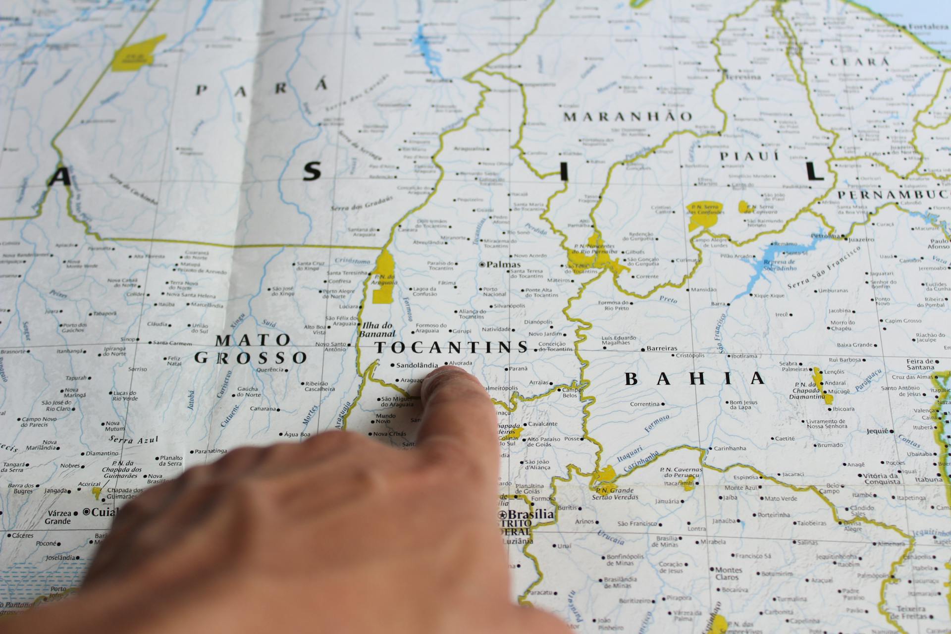 Close-up of a finger pointing to Tocantins on a map of Brazil.