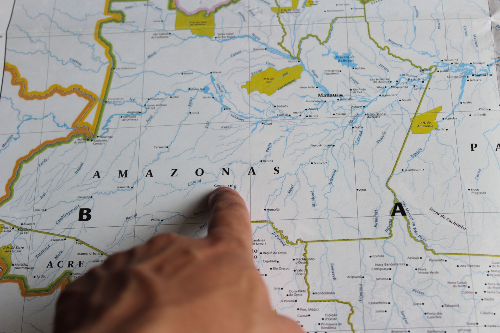 Photo of a hand pointing at Amazonas on a detailed map of Brazil.
