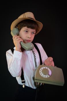 A retro-themed portrait of a boy in hat and suspenders holding a rotary phone, exuding vintage charm.
