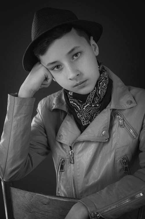 Grayscale Photo of Boy Wearing Leather Jacket