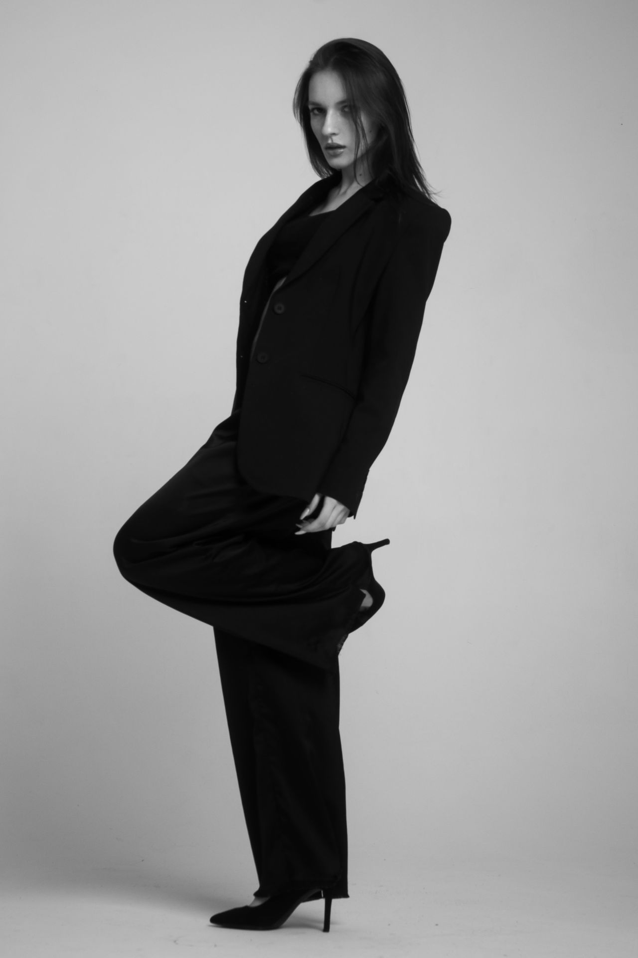 Woman in a black blazer and wide-leg trousers with heels