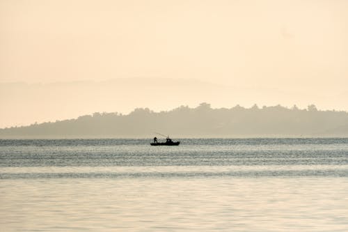 Silhouette of People on Boat on Body of Water 