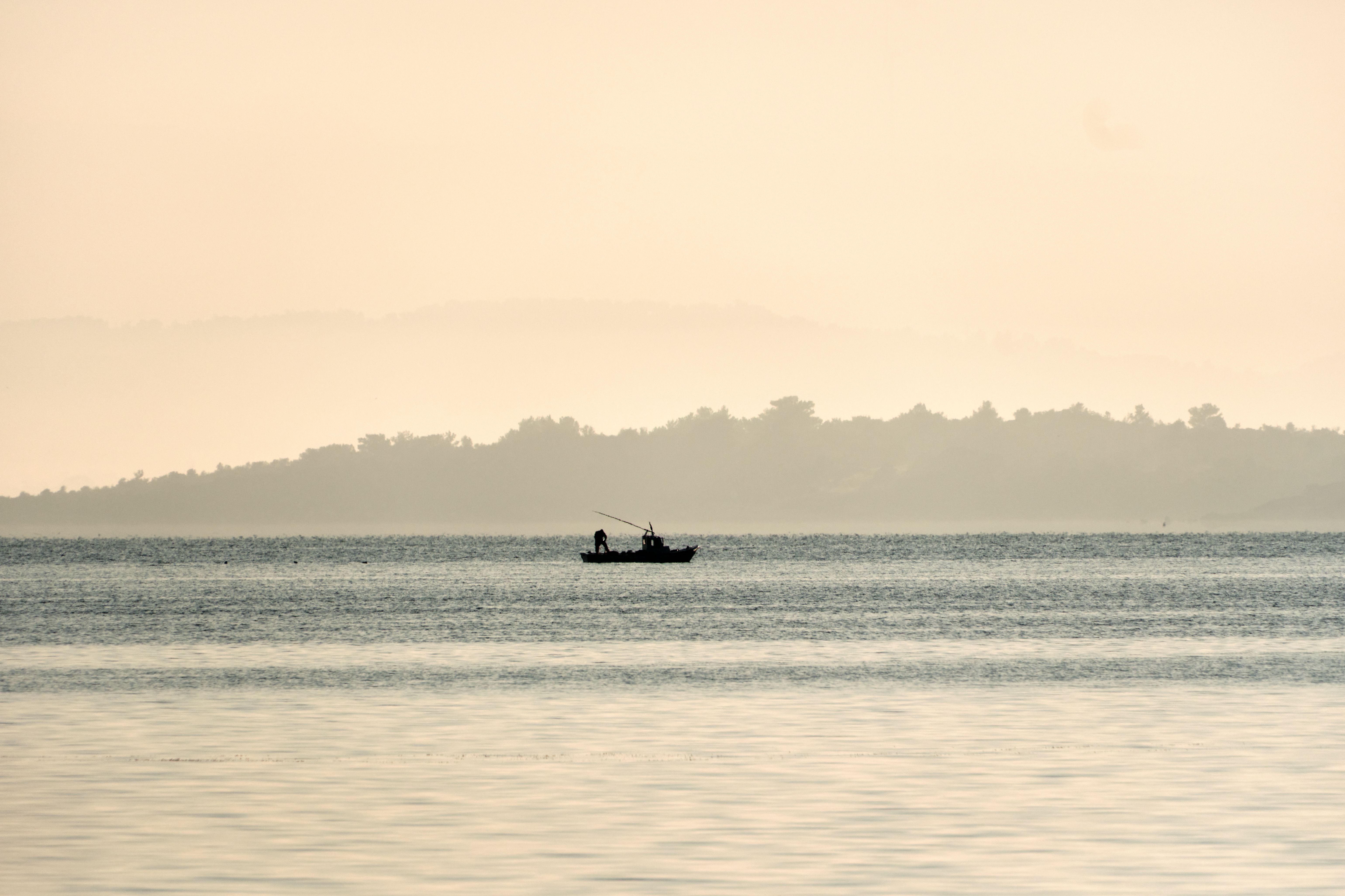 Silhouette of People on Boat on Body of Water · Free Stock Photo
