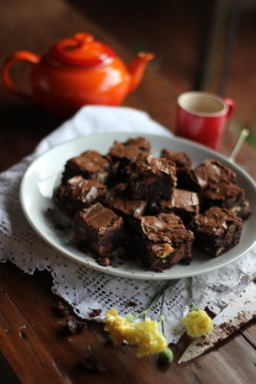 Plate of Brownies next to a Kettle