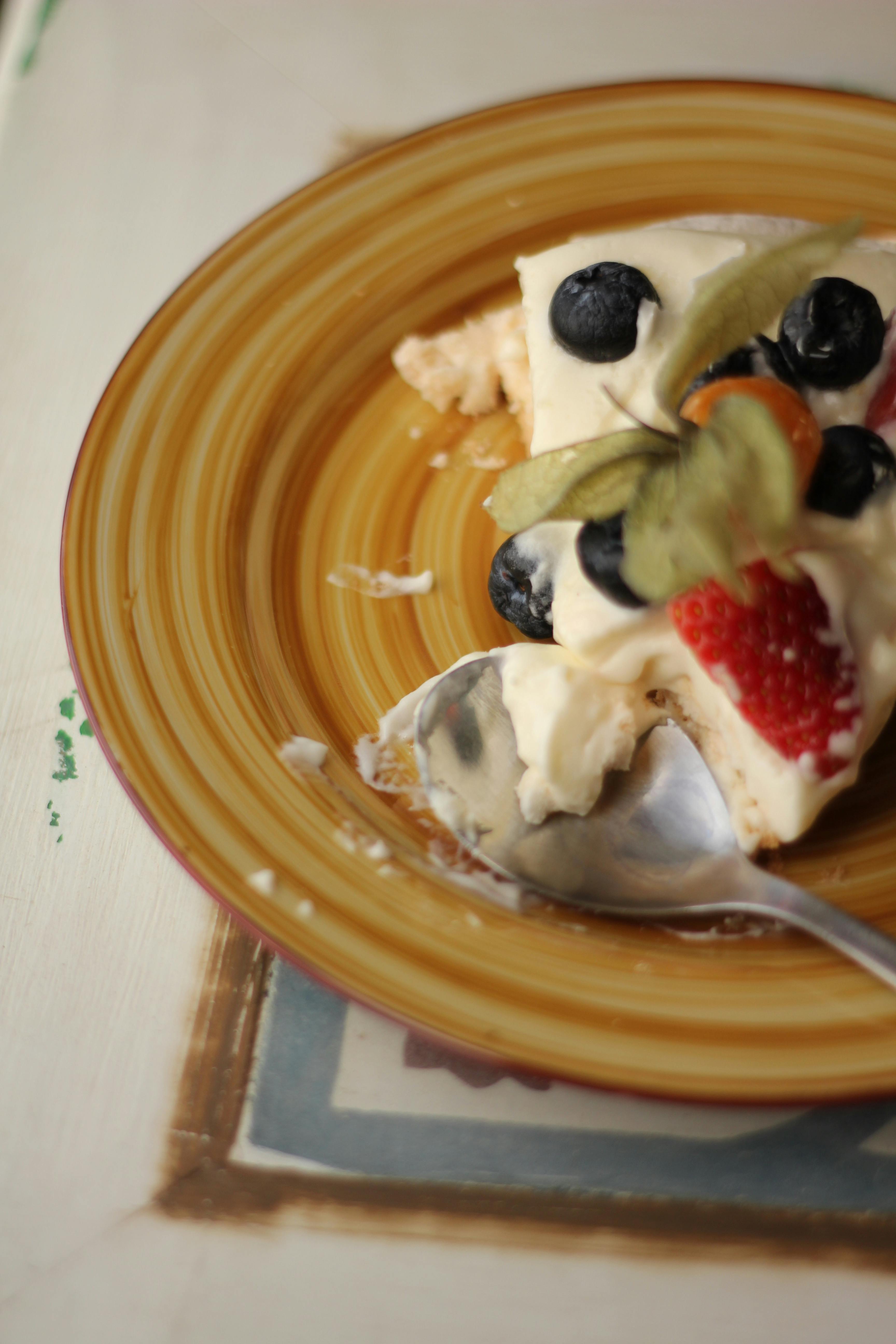 Delightful slice of cheesecake with fresh berries on a rustic wooden table.