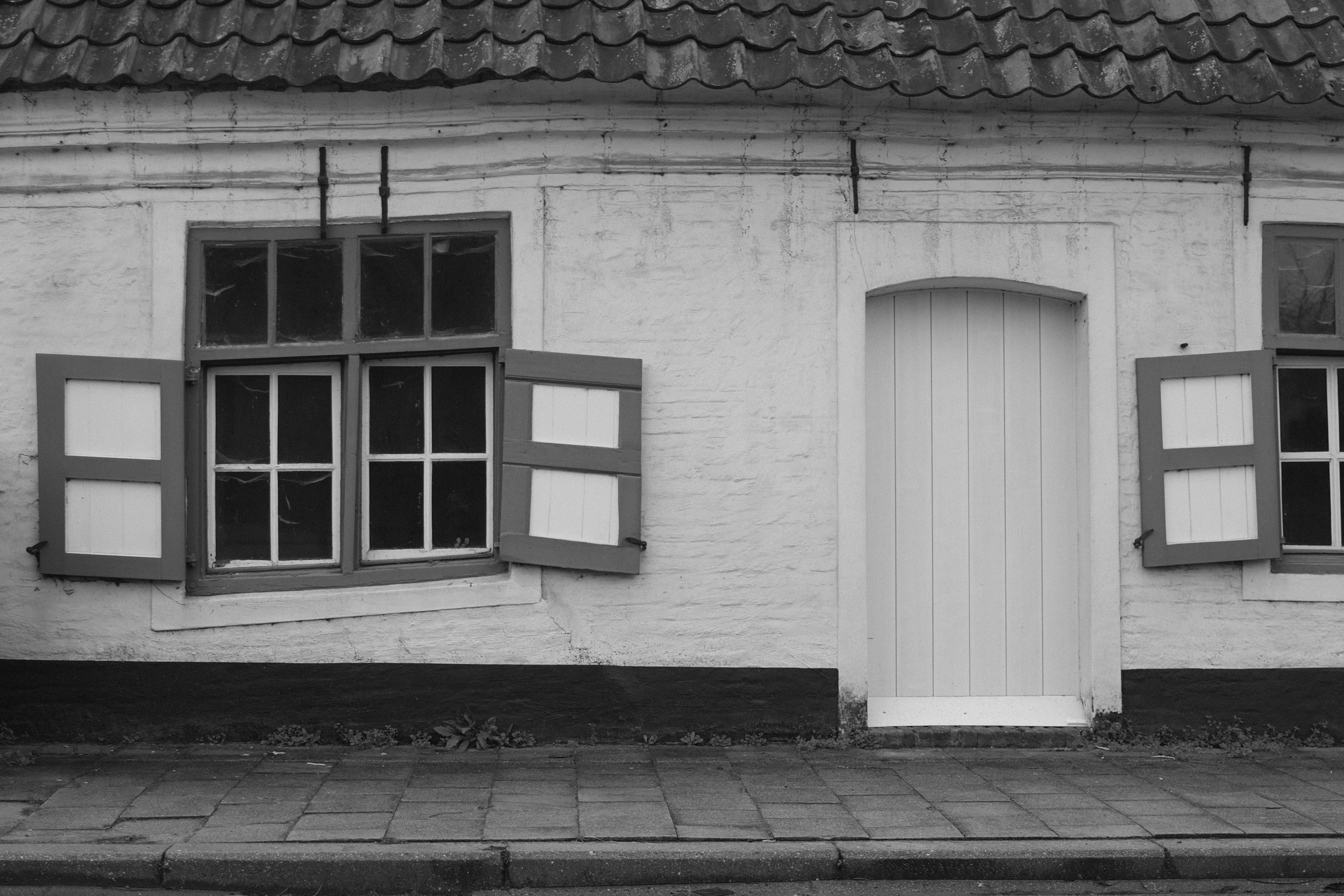Black and white facade with windows and door in Ghent, Belgium, featuring traditional architectural style.