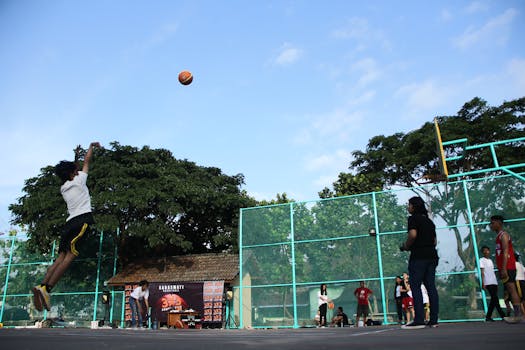 Players enjoying a lively game of basketball on a sunny outdoor court.