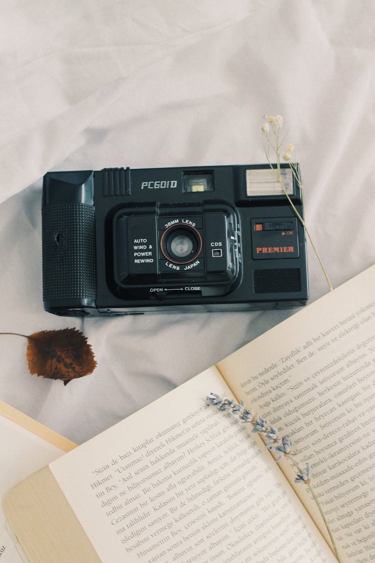 Vintage Camera Next To A Book 