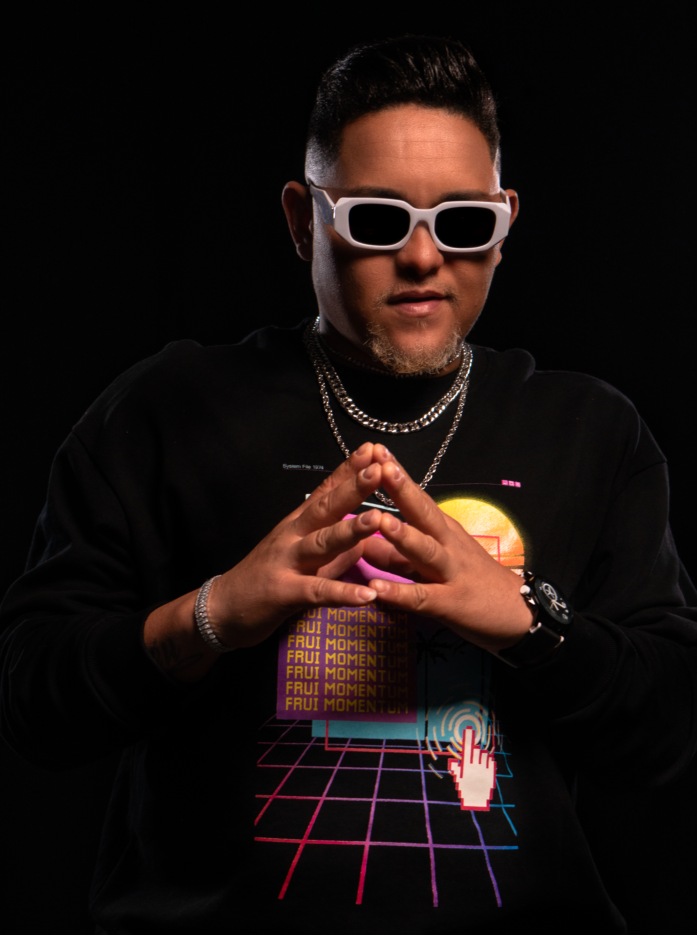 Fashionable man wearing sunglasses and a graphic sweater in a studio setting, São Paulo.
