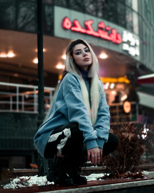 Free Stylish young woman with long hair poses in urban Iran at dusk, showcasing modern fashion. Stock Photo