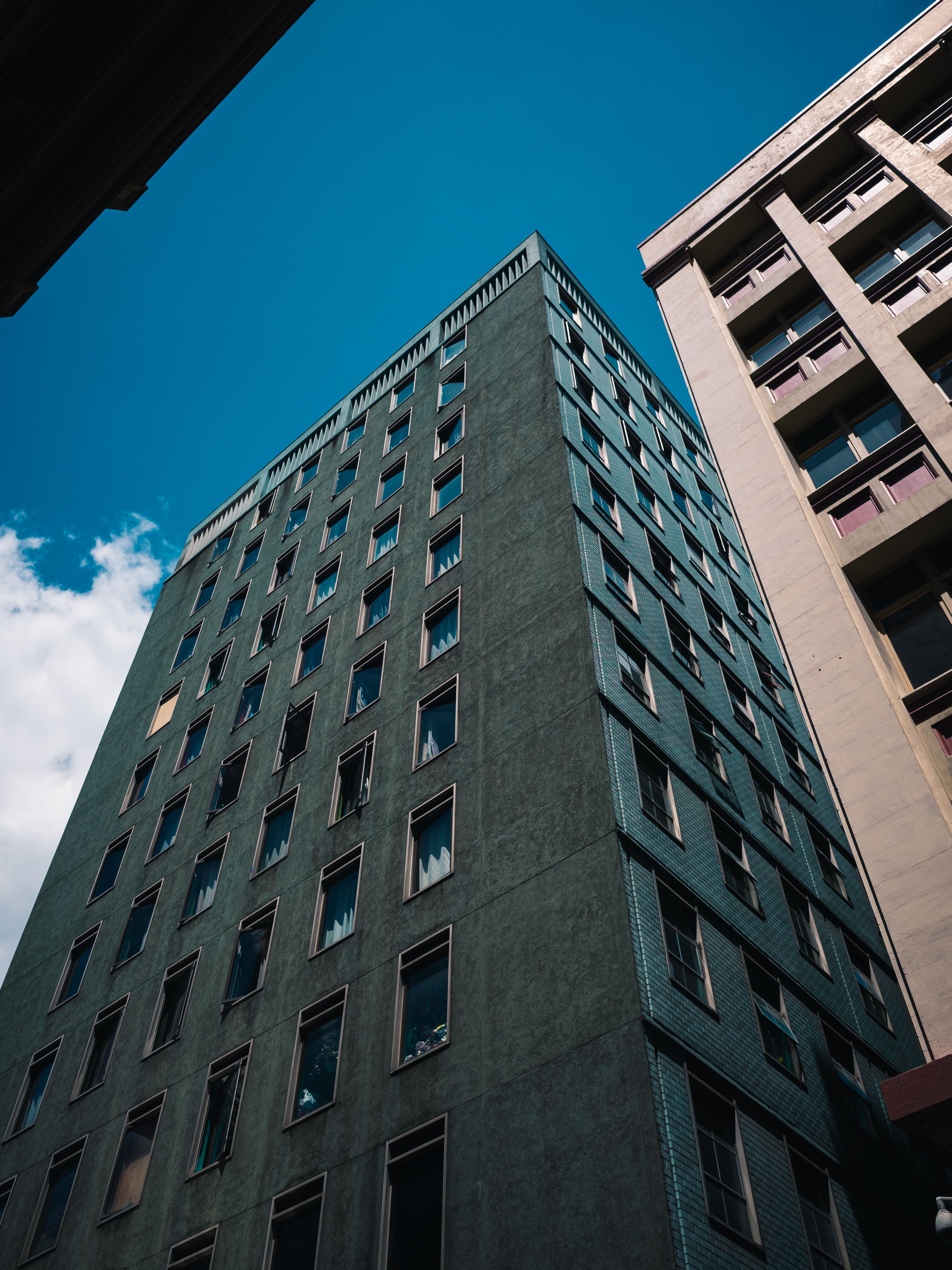 Low Angle Shot of Apartment Buildings Under Blue Sky · Free Stock Photo