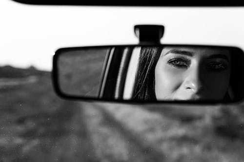 Woman Face Reflection in Car Mirror