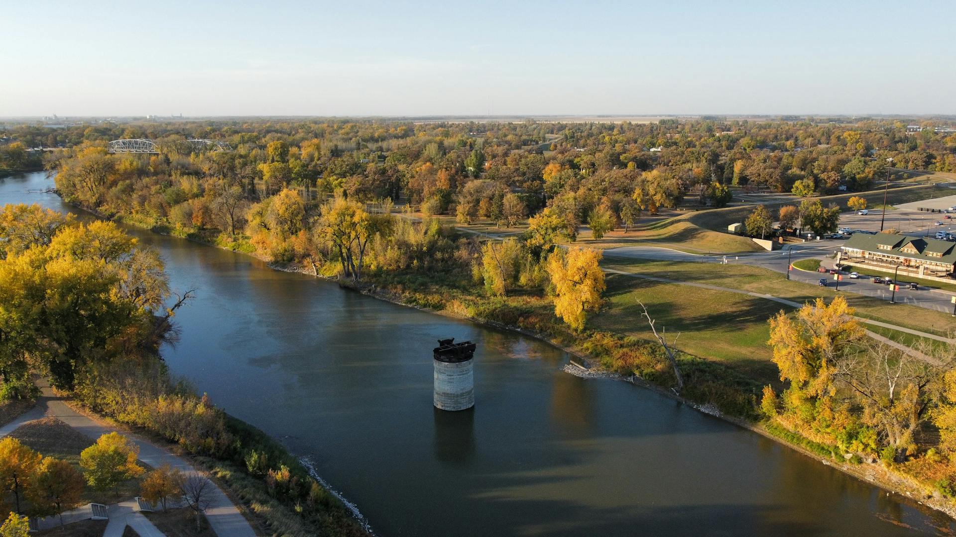 A scenic aerial view of a river surrounded by fall foliage in Grand Forks, North Dakota.