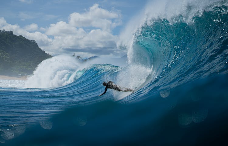 Man Surfing On Wave In Ocean