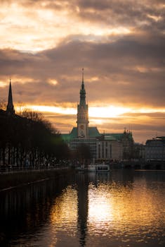 Dramatic sunset over Hamburg's Rathaus, reflecting on the River Alster.