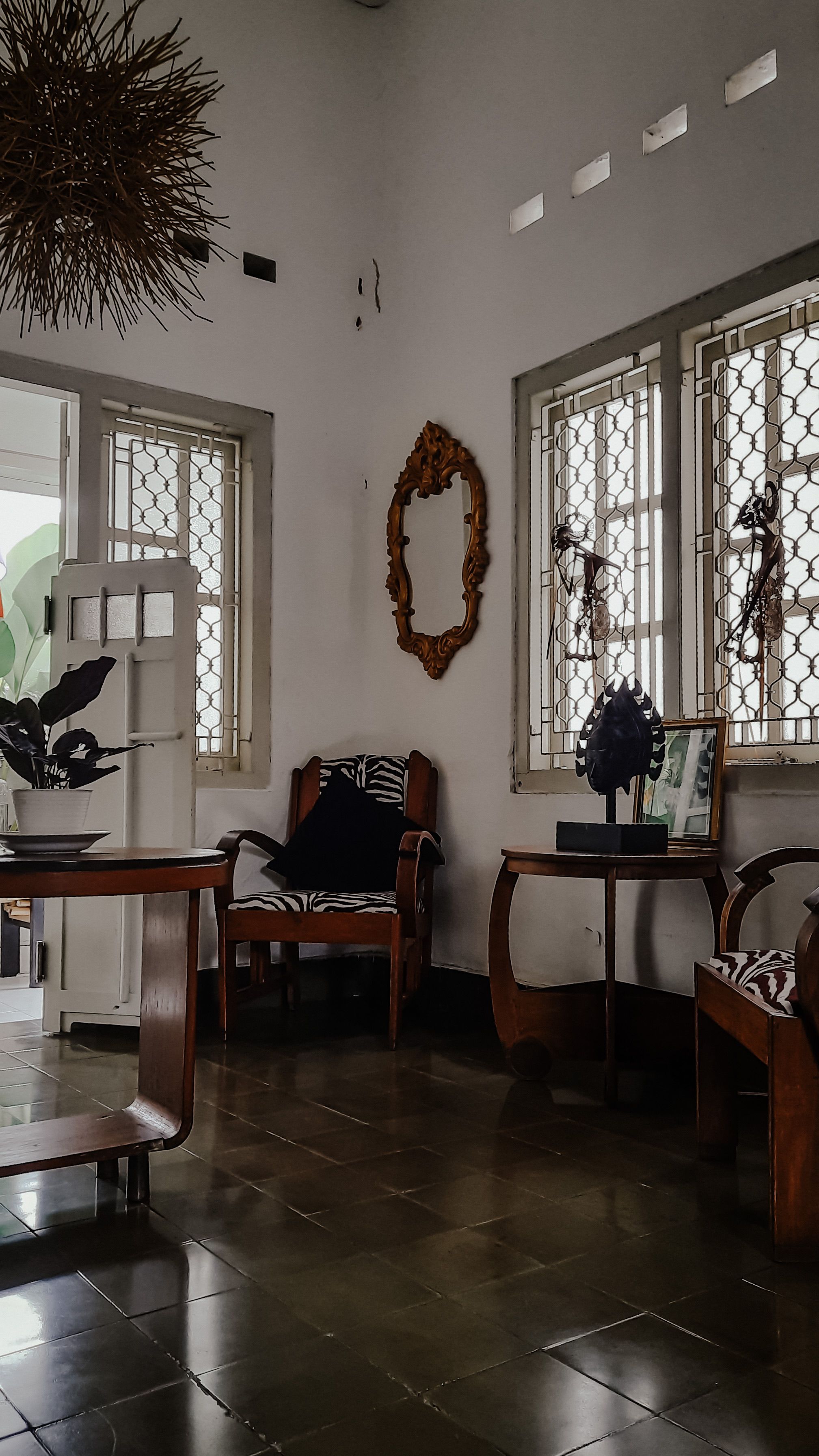 Elegant room showcasing vintage armchairs, artistic decor, and white walls.