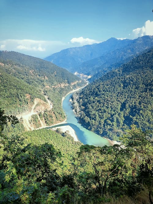 Aerial View of River in Between Green Mountains