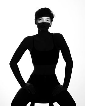 Artistic black and white silhouette of a woman with short hair sitting confidently.