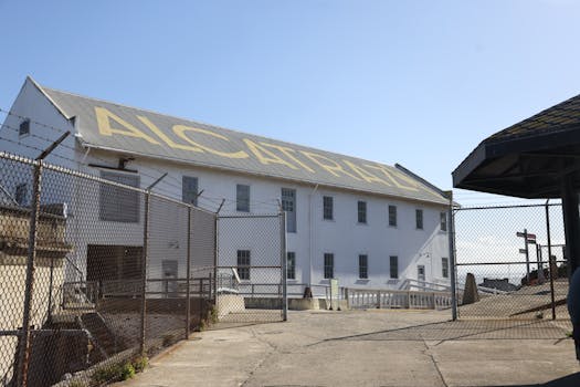 Exterior view of Alcatraz Island prison building under clear blue sky.