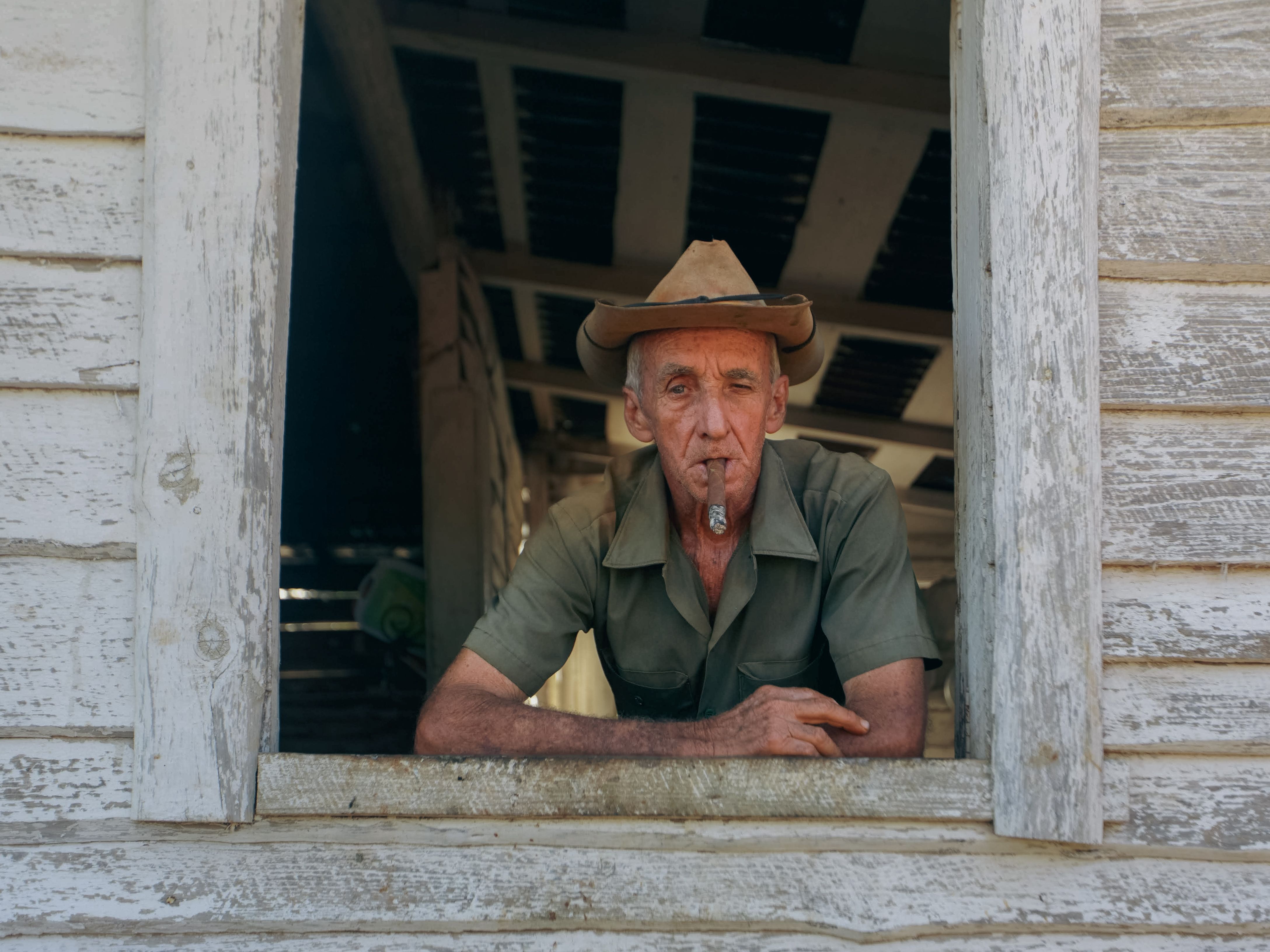 Man with Cigar in Window Opening · Free Stock Photo