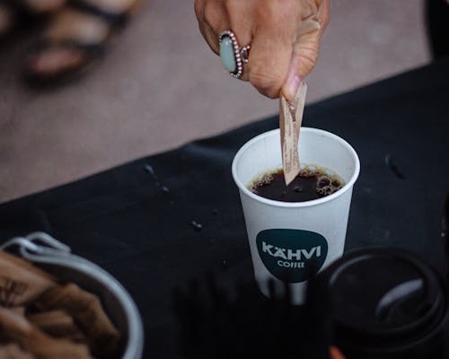 Person Making Coffee in a Disposable Cup