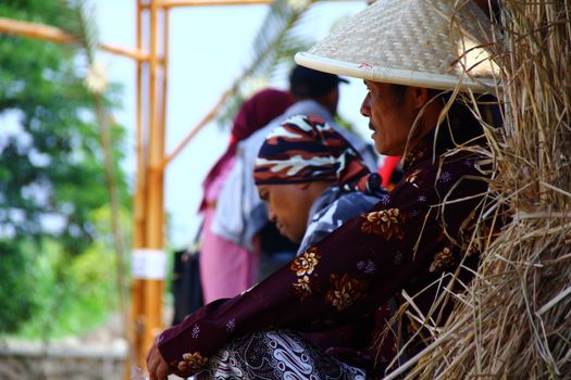 Traditional farmers in colorful clothing take a break outdoors, highlighting rural life.